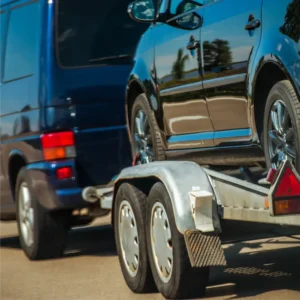 Vehicle transported securely on a dual-axle trailer.