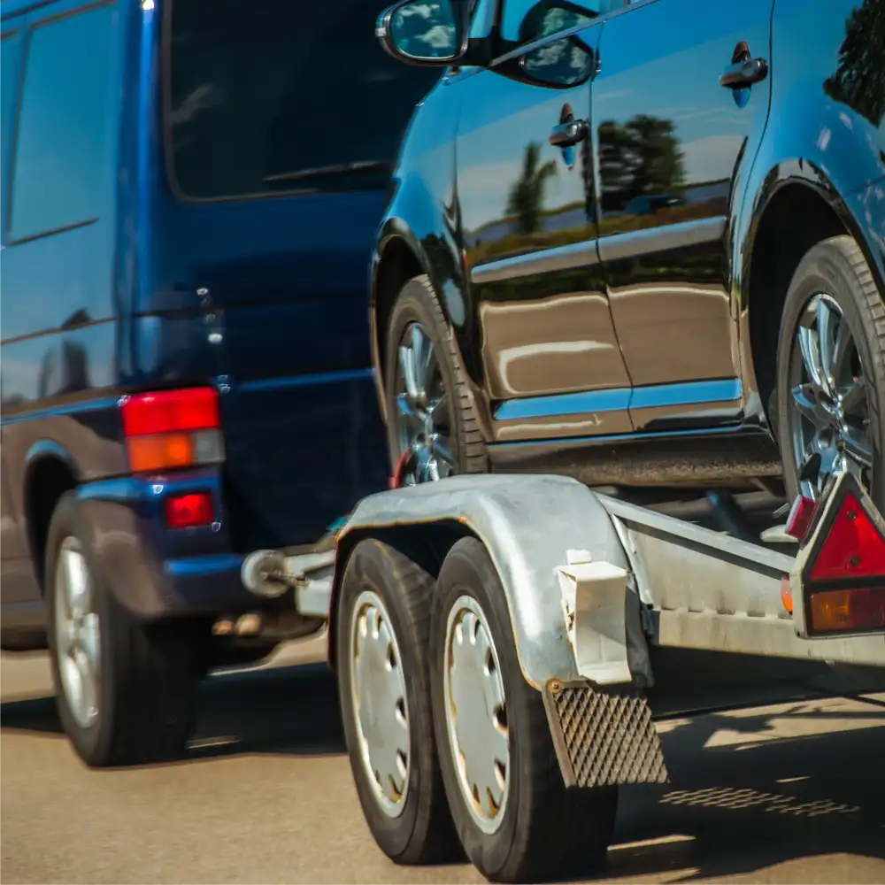 Vehicle transported securely on a dual-axle trailer.