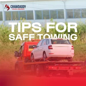 Flatbed tow truck safely transporting car demonstrating essential towing safety practices