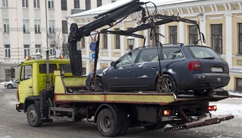 SUV being towed through a city area by Crawdaddy Towing and Recovery.