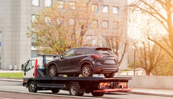 Multiple vehicles being transported securely using professional towing equipment.