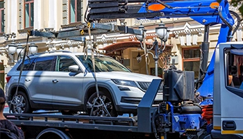 White SUV transported on a flatbed tow truck for safe and damage-free towing.