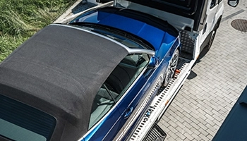 High-end vehicle carefully towed on a flatbed truck by professional operators.