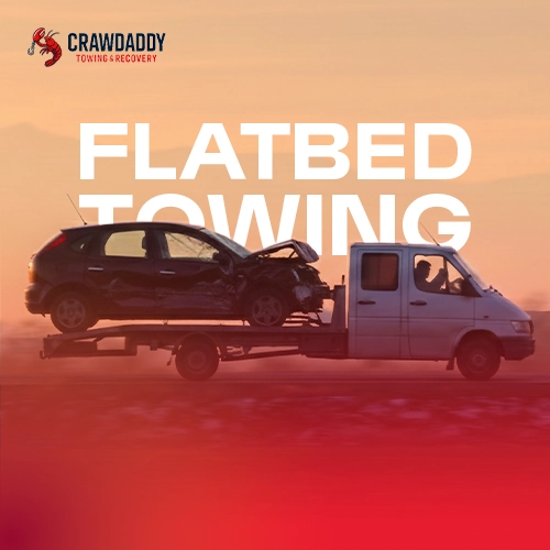 flatbed truck transporting damaged car during emergency 24/7 towing service